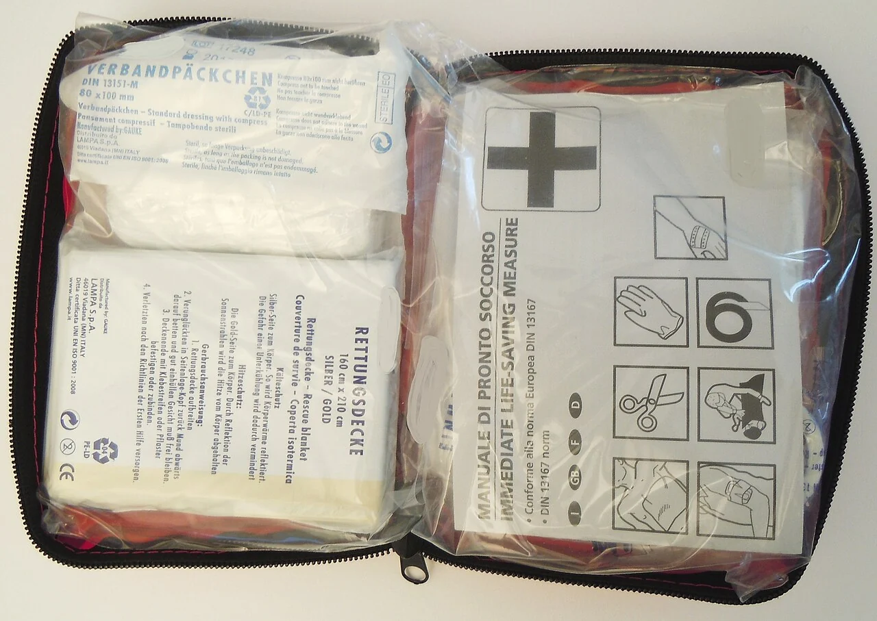 An open first-aid pouch containing individually packaged dressings and supplies.