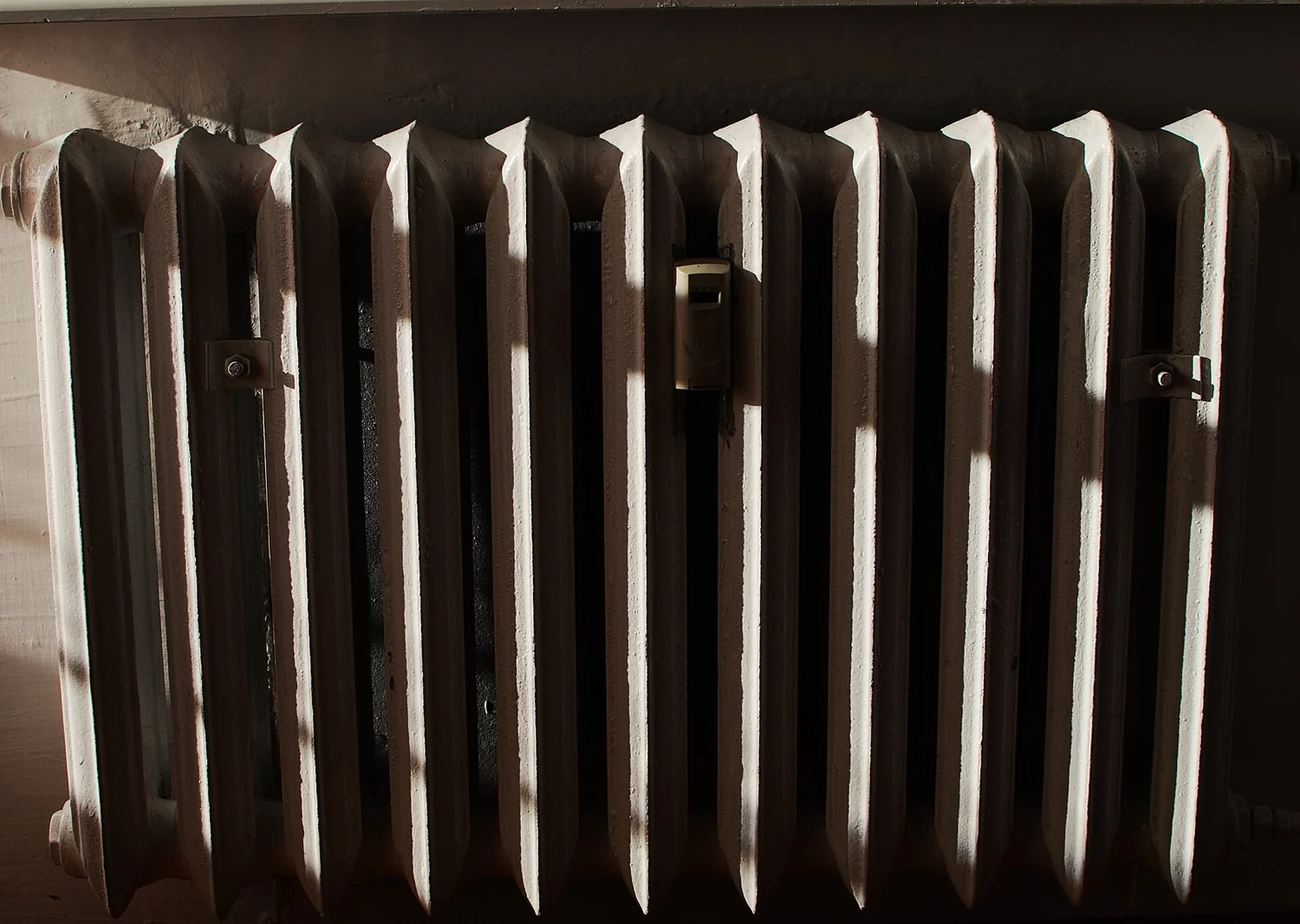 A domestic radiator beside a wall.